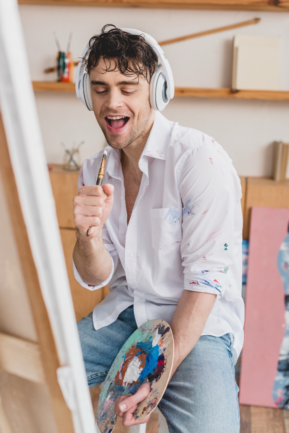 A cheerful artist wearing headphones