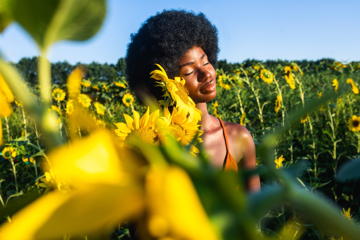 A woman smiling in a sunflower field